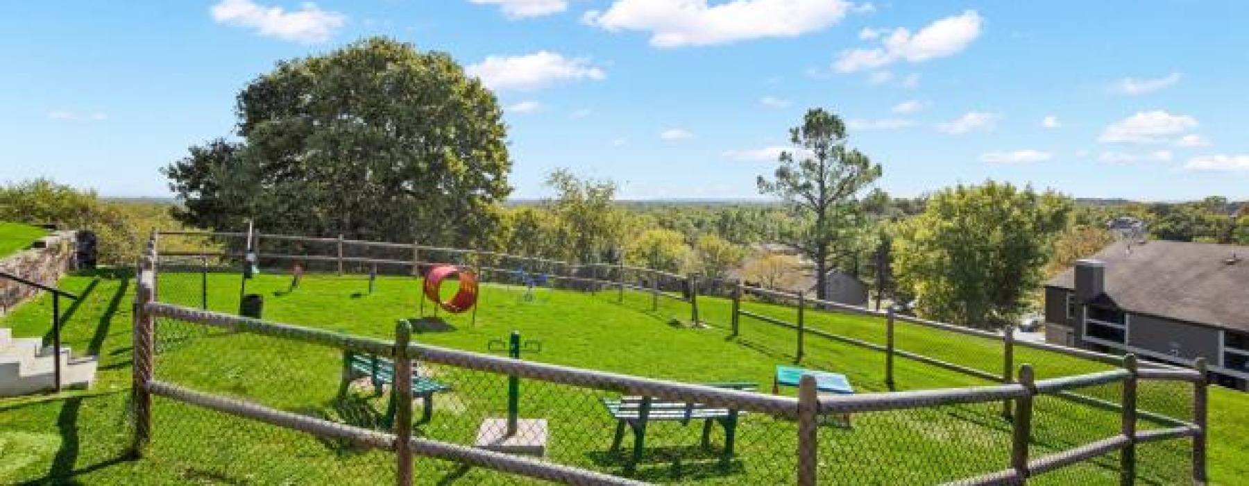a dog park with benches and a wooden fence