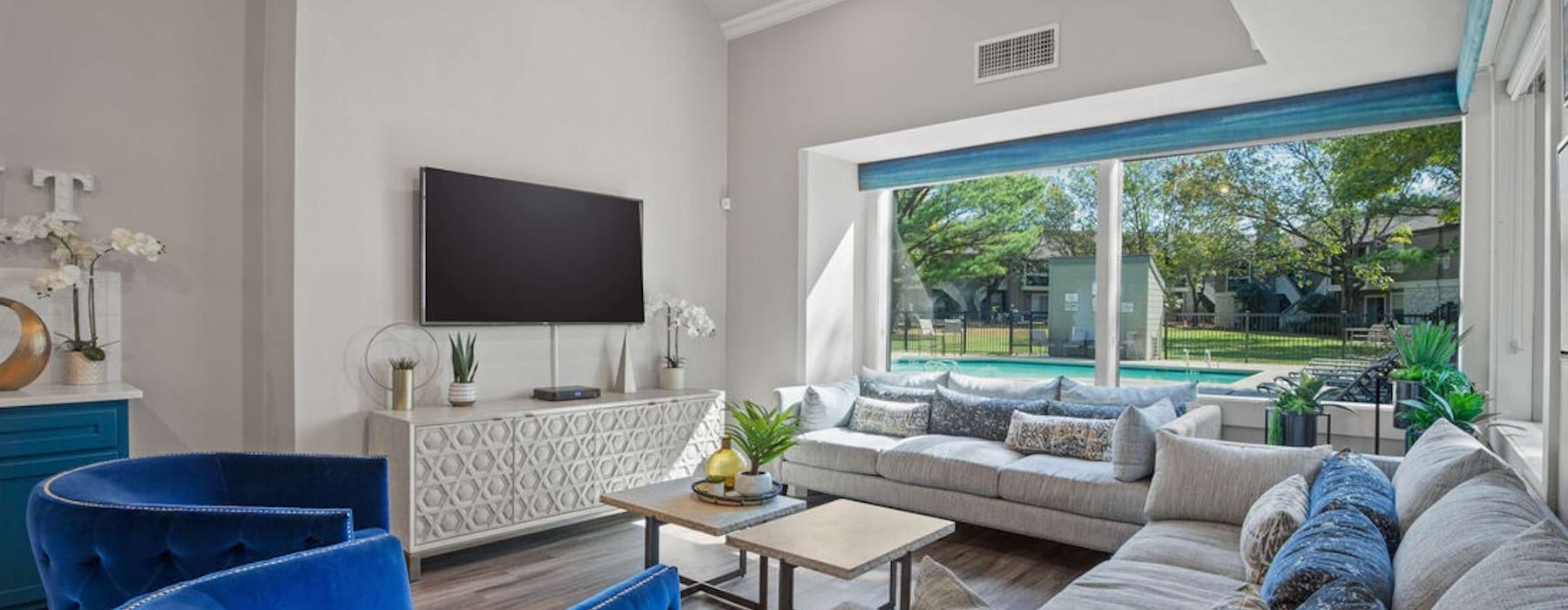 a room with a tv, a couch and chairs