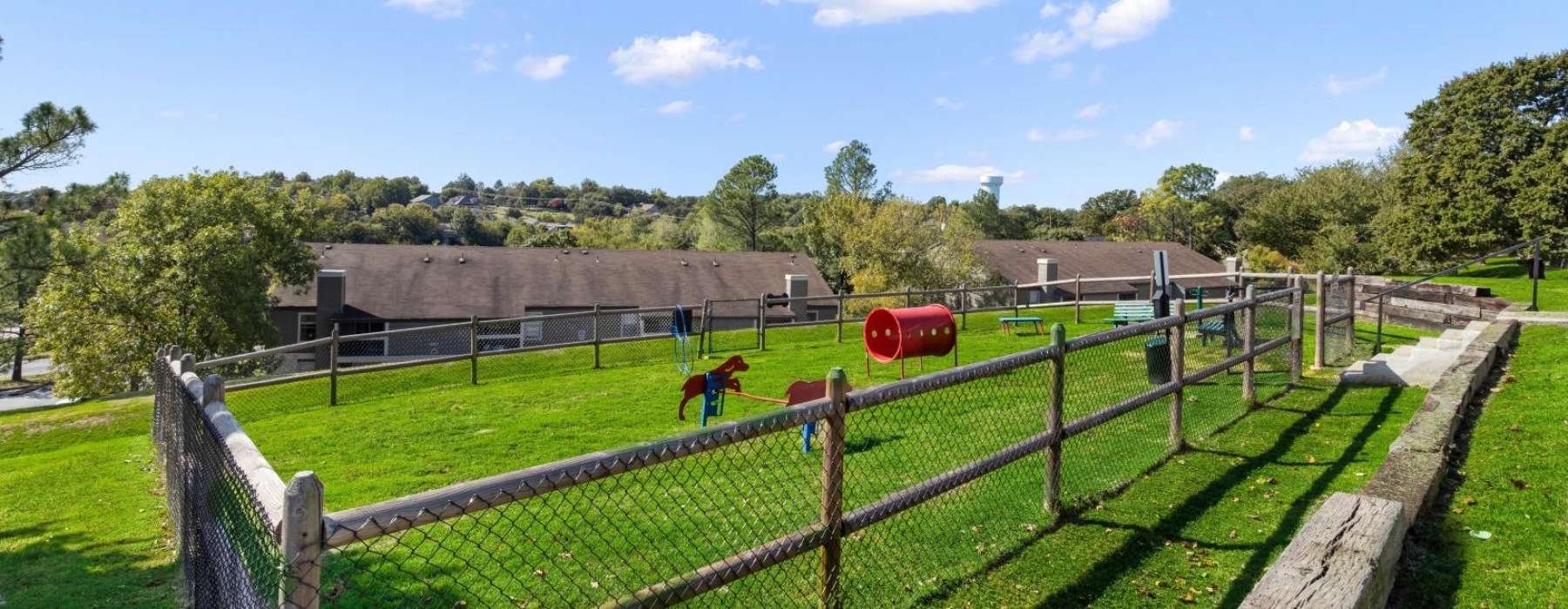 a dog park with benches and a wooden fence